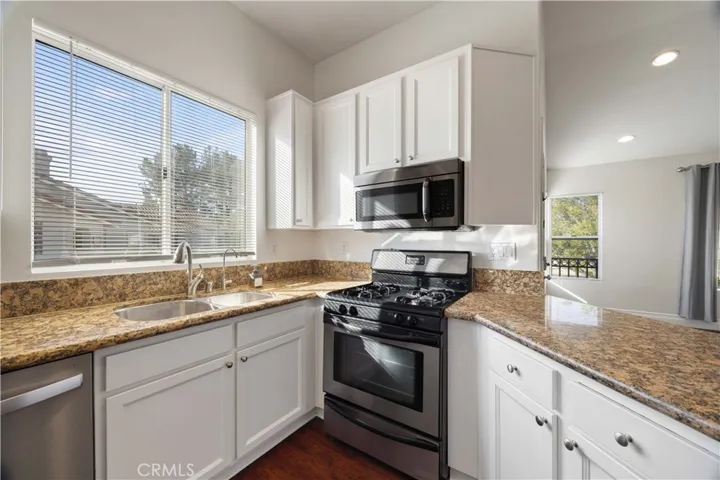 Granite countertops, white cabinetry and stainless steel appliances.