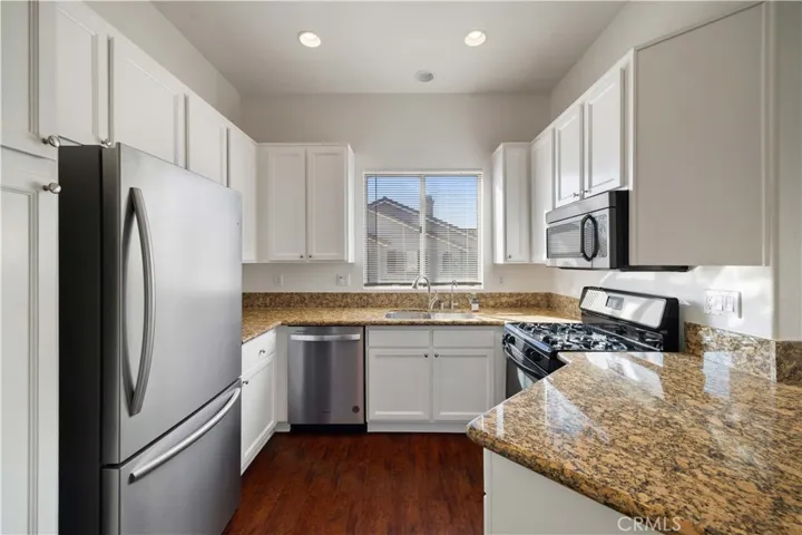 Granite countertops, white cabinetry and stainless steel appliances.