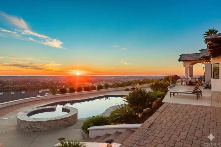 The vibrant sunset features bright orange and yellow hues fading to clear blue sky. This is home.