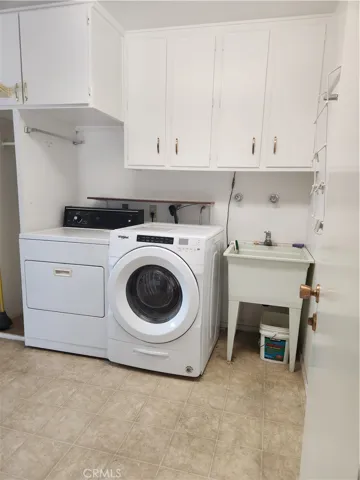 Huge laundry room with wash basin, newer Washer to stay for Buyer.  Older dryer will be removed