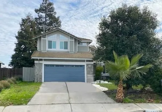 View of front of home with driveway and an attached garage