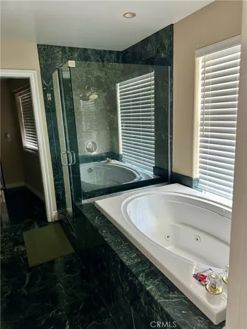Jetted tub and glass standing​​‌​​​​‌​​‌‌​​‌​​​‌‌​​​‌​​‌‌​​‌‌​​‌‌​​​​ shower