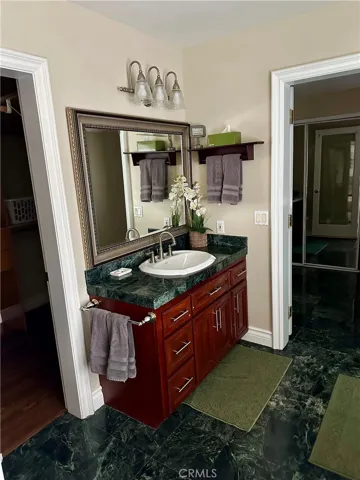 Bathroom with doors to large walk-in closet and kitchenette with an extra closet