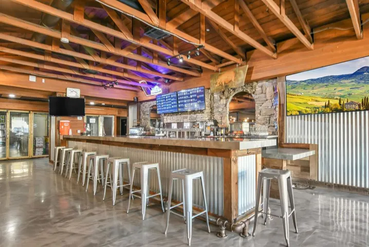 Indoor dry bar with brown cabinets and a wood ceiling with exposed beams