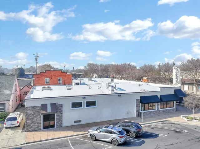 View of building exterior featuring uncovered parking