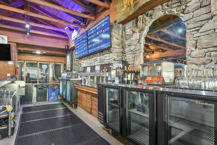 Bar featuring wooden ceiling and wood walls