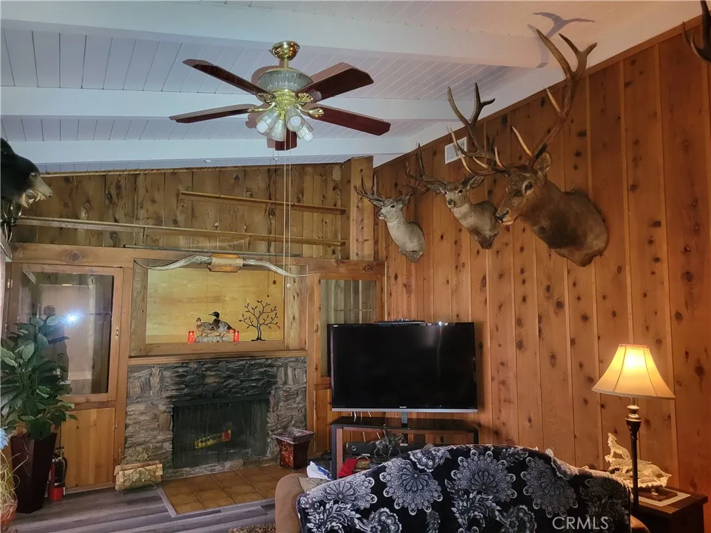 Den has high open wood beam ceiling