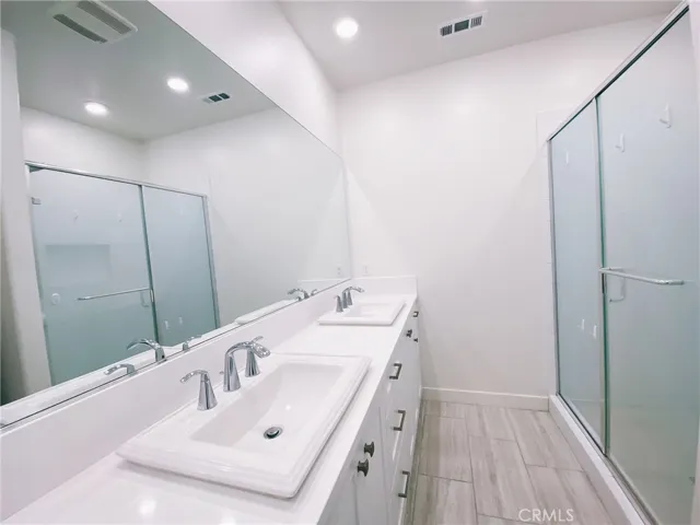 Primary bathroom has double sinks and walk-in shower.
