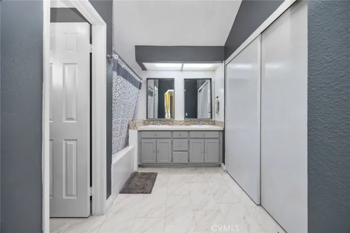 Primary room bathroom dual sink, private toilet room and closet.
