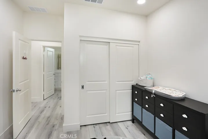 Alternate view of bedroom showing closet access and adjoining hallway.