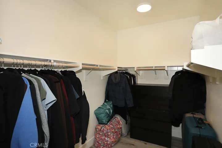 Walk-in closet with built-in hanging rods and shelving for organized storage.