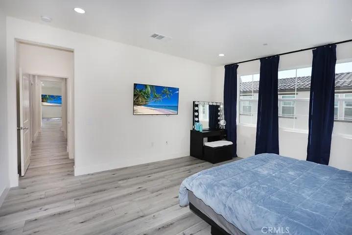 Alternate view of primary bedroom showing flexible layout and window placement.