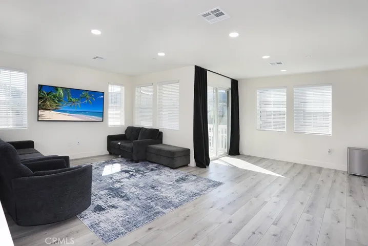 Open-concept upper-level living area with abundant natural light and access to outdoor balcony.