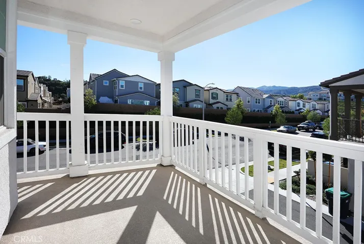 Covered second-level balcony offering outdoor living space with neighborhood and hillside views.