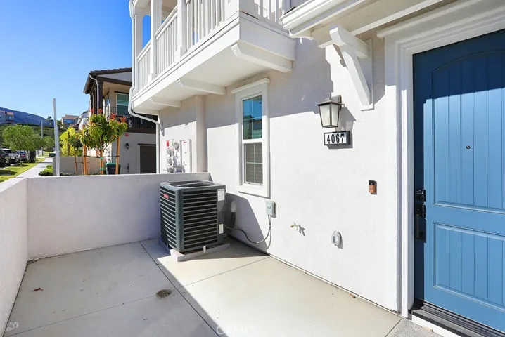 Ground-level concrete patio area adjacent to entry, offering private outdoor space.