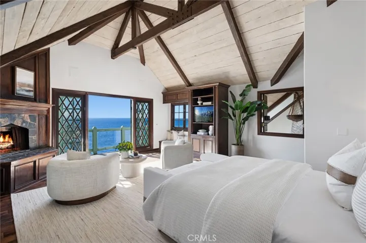 The primary suite offers a private ocean-view deck, fireplace, dual baths, and a walk-in closet—a serene retreat overlooking the sea, with panoramic coastal views, Catalina Island, sunsets, and sparkling night lights.