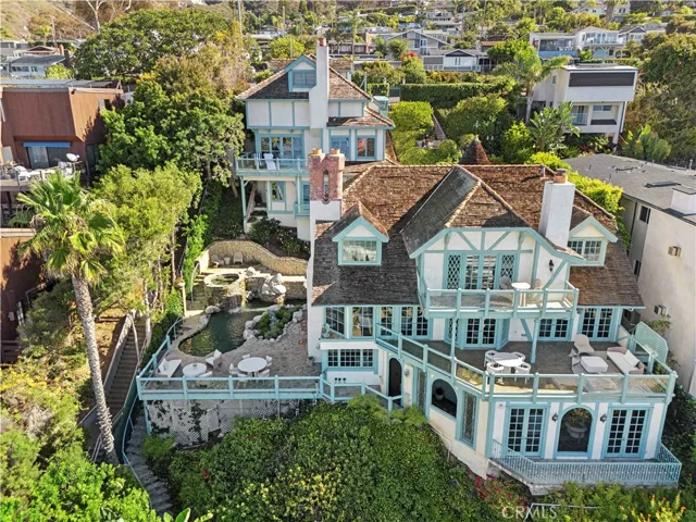The main residence feels both grand and enchanting, with a stone turret, diamond-patterned windows, and a shingled roof that mirrors the rhythm of the waves below.