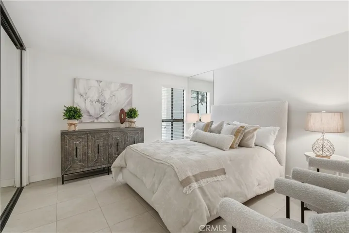 Spacious bedroom with wall to wall closets with mirrored wardrobe doors