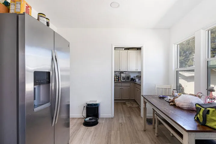 Kitchen with stainless steel refrigerator with ice dispenser and light wood-style floors