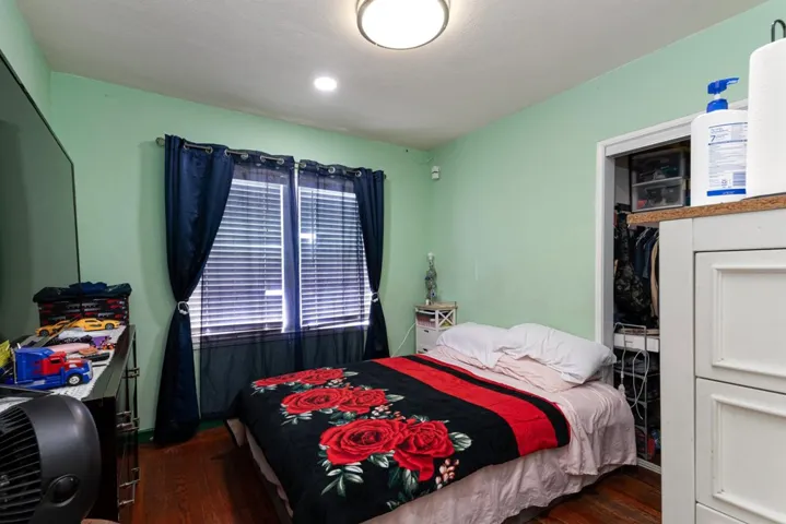 Bedroom featuring dark wood finished floors and a closet