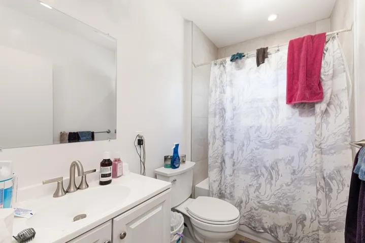 Bathroom featuring shower / tub combo with curtain and vanity