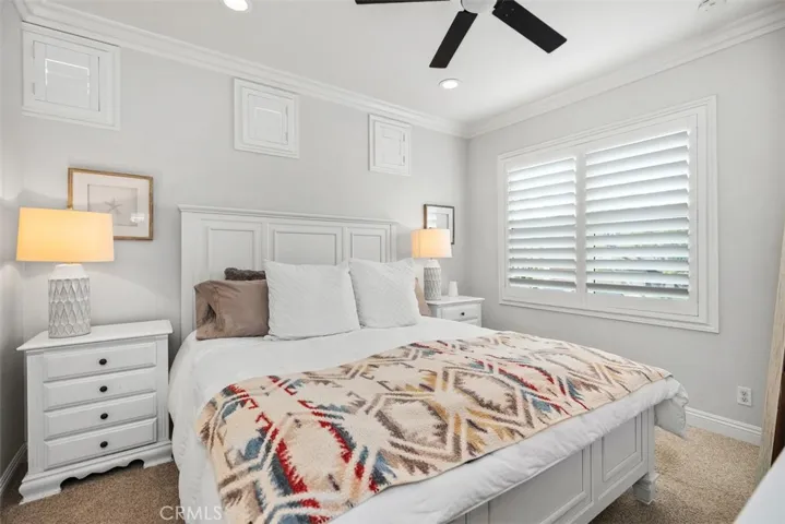 The primarty bedroom features, newer paint, carpet,  crown mouldingmoulding and cooling ceiling fan!
