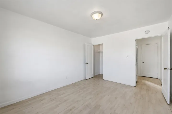 Unfurnished bedroom featuring light wood finished floors and a closet