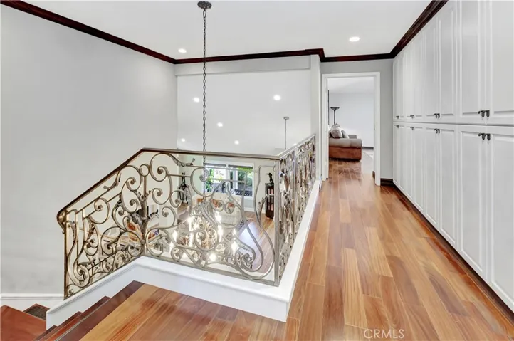 Elegant staircase railings leading to the upstairs hallway,enhanced with new built-in cabinets.