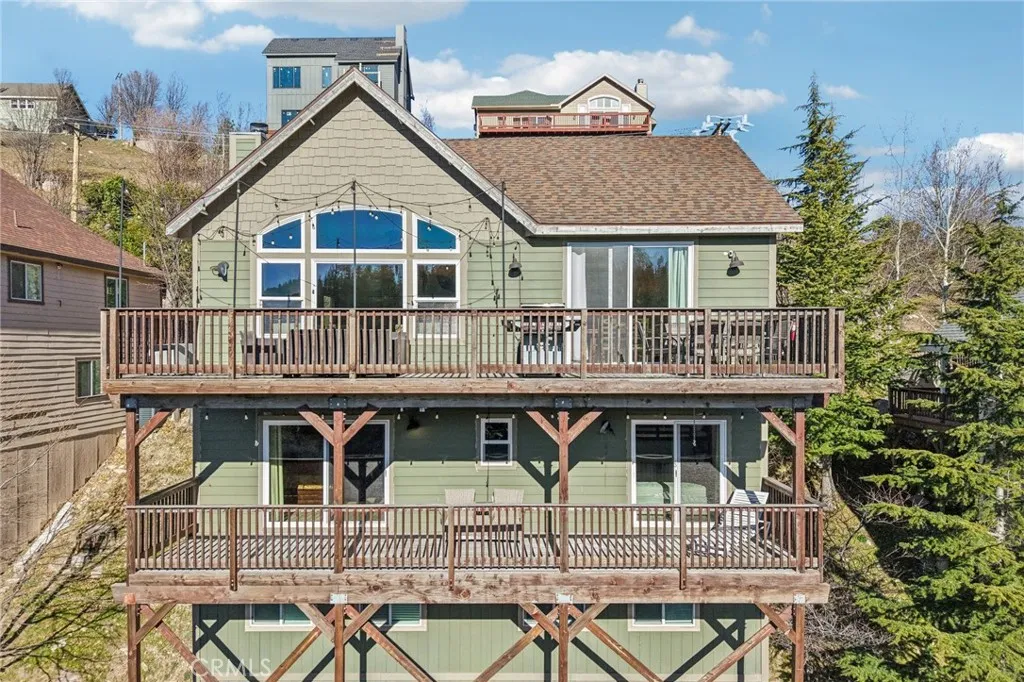 Dramatic great-room windows and wraparound upper deck capture the scenery.