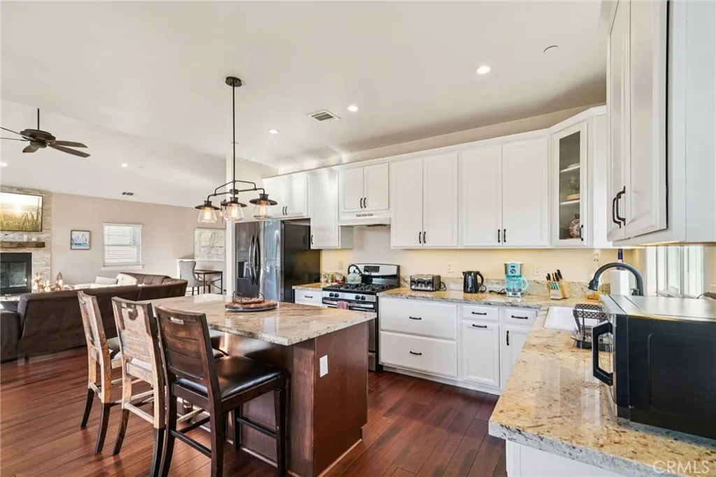 Slab-granite worktop, trio of pendants, and seating for four; effortless flow to the great room.