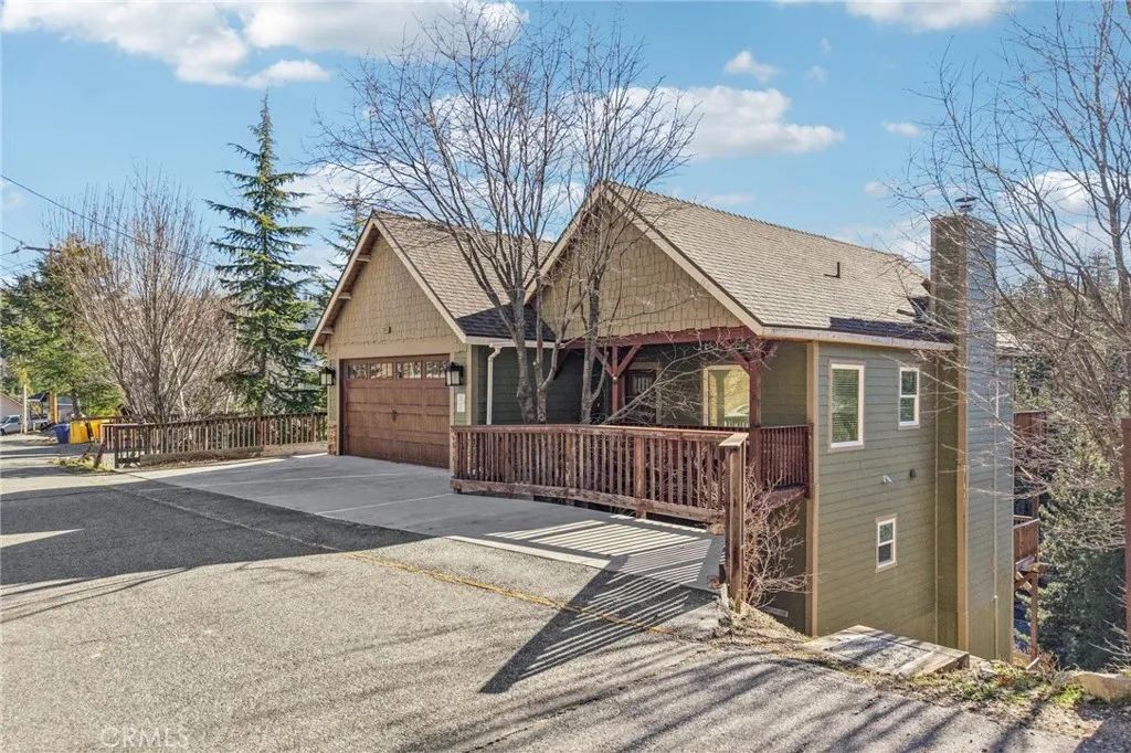Forest-backed mountain home with craftsman details, timber accents, and an attached 2-car garage.