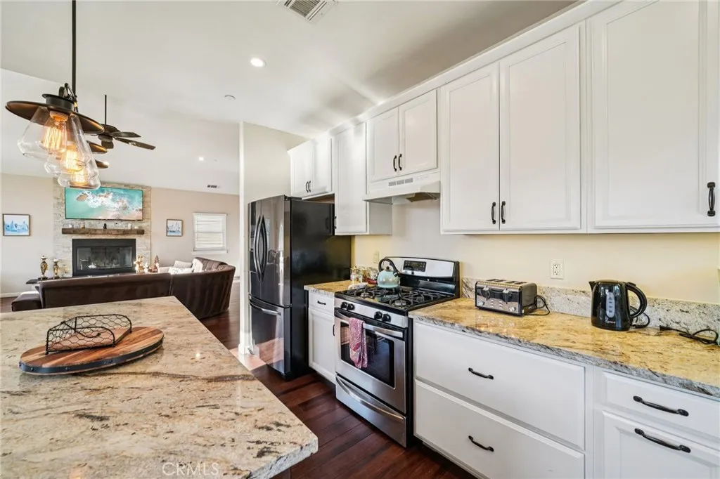 Gas range framed by expansive counter space and white Shaker cabinetry.