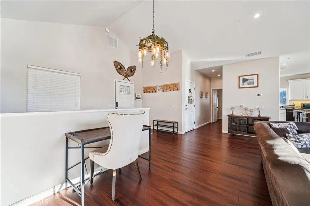 Vaulted ceilings and wide-plank floors anchor an airy, open-concept layout with flexible seating and workspace.