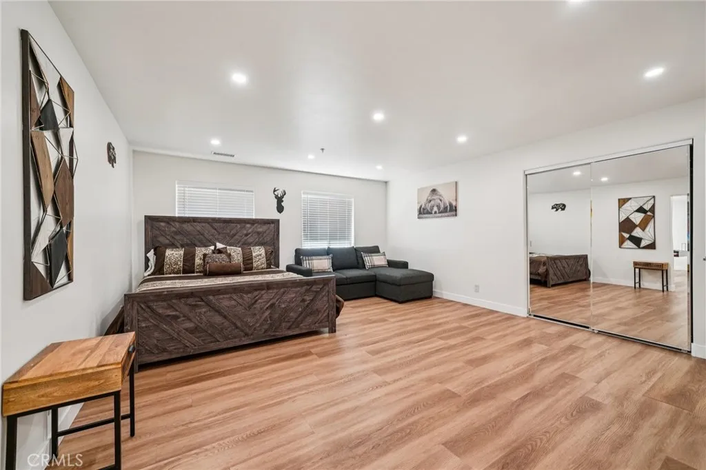 Huge lower-level suite with mirrored closet, seating area, and recessed lighting.