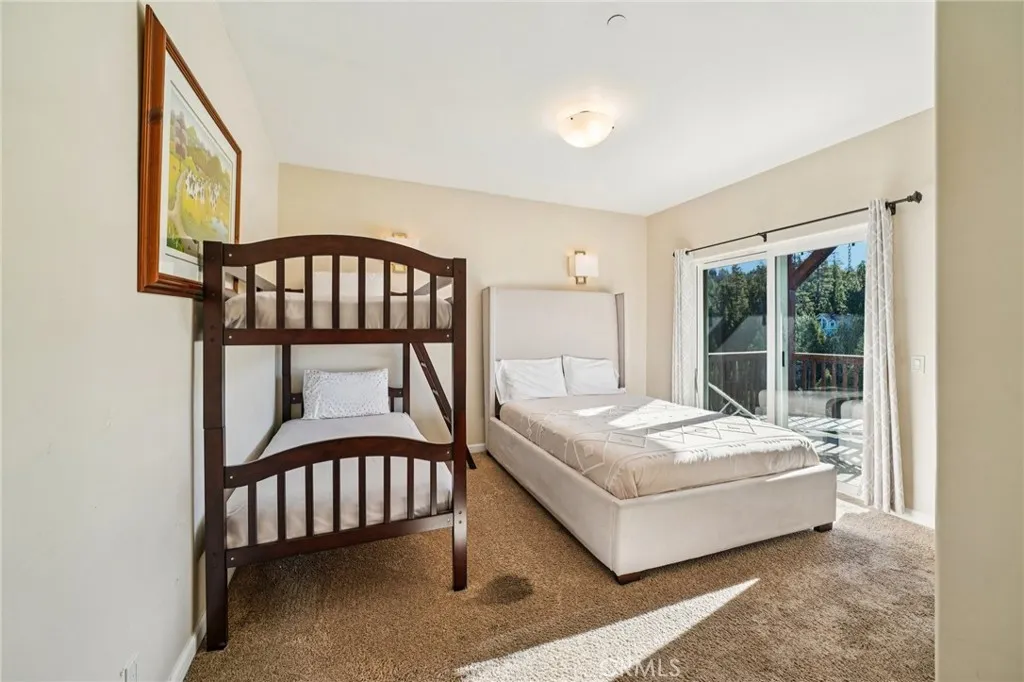 Spacious guest room with slider to the shared deck and peaceful forest outlooks.