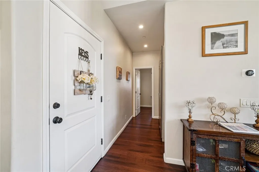 Wide corridor off the great room with hardwood floors leading to the private quarters.