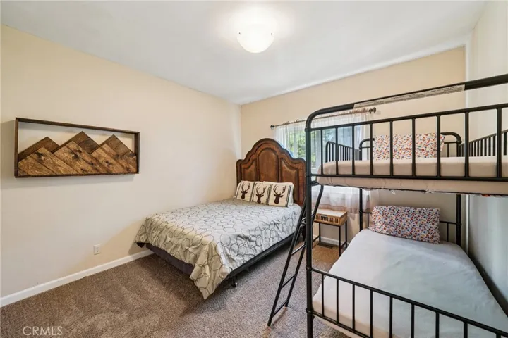 Comfortable guest room with window light and space for multiple beds.