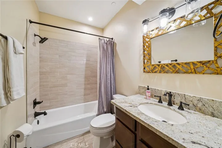 Full bath with tiled shower-over-tub, granite vanity, and updated fixtures.