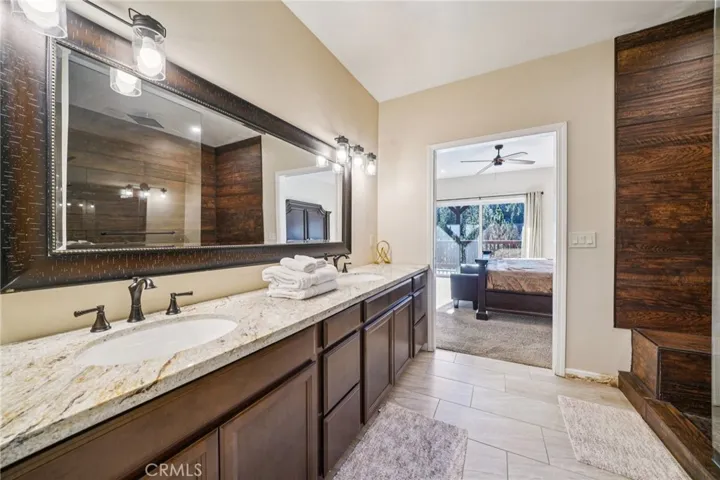Dual sinks with granite counters and wide mirror; spa-like proportions.