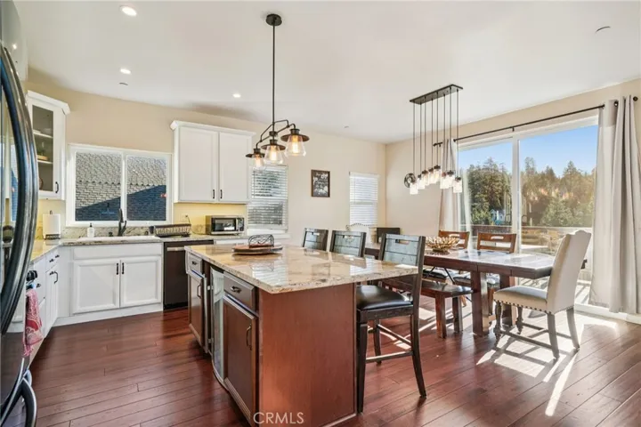 Granite island with bar seating opens to the window-lined dining area and deck.