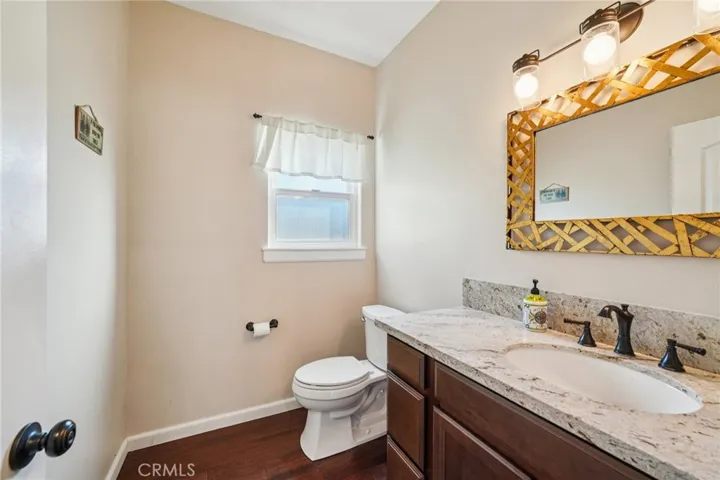 Convenient main-level half bath with granite-topped vanity and window for natural light.