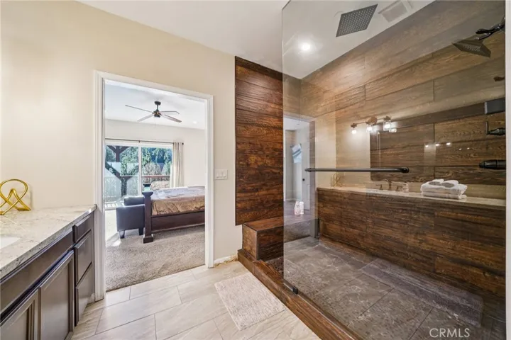 Oversized, glass-enclosed walk-in with bench seating and rain shower head.