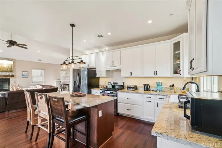 Slab-granite worktop, trio of pendants, and seating for four; effortless flow to the great room.