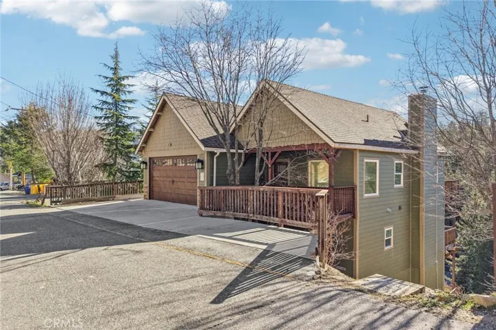 Forest-backed mountain home with craftsman details, timber accents, and an attached 2-car garage.