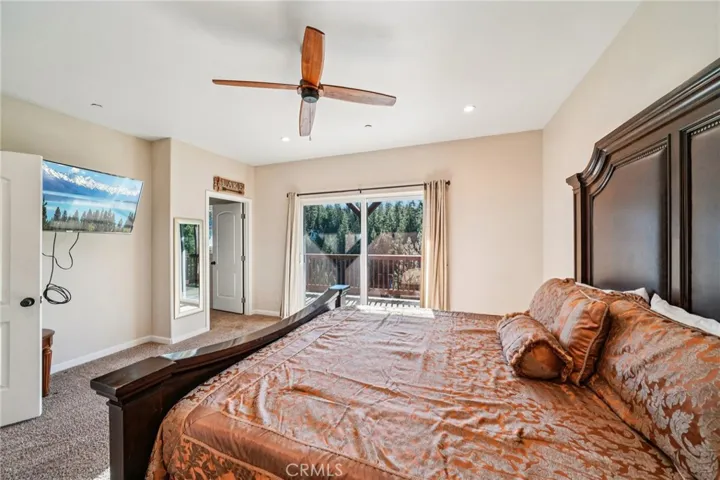 Natural light and access to a deck overlooking the forest at the primary bedroom.