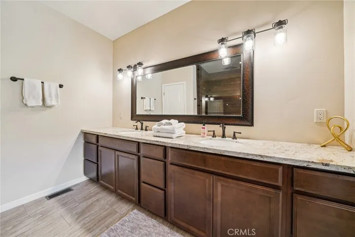 Oil-rubbed fixtures, abundant storage, and wide framed mirror.
