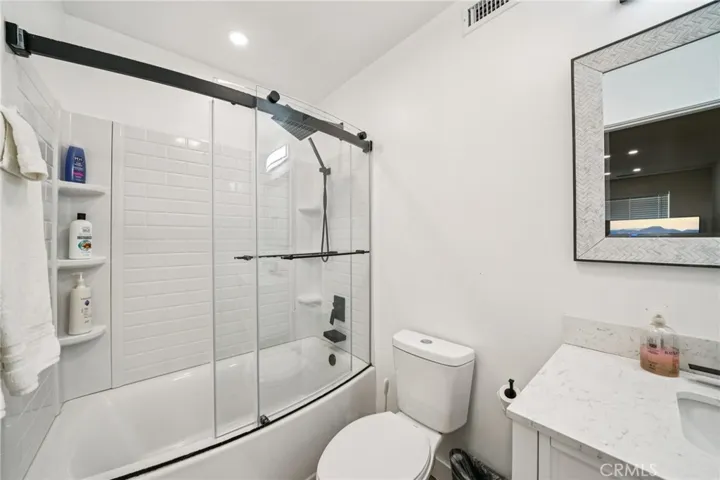 Curved glass doors and built-in niches add style and storage.