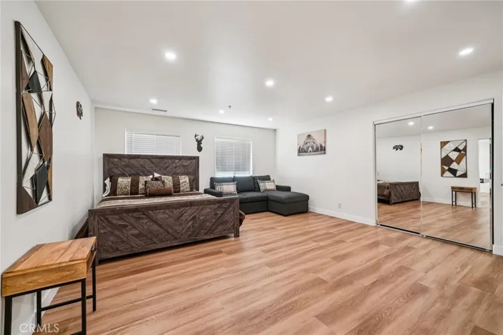 Huge lower-level suite with mirrored closet, seating area, and recessed lighting.