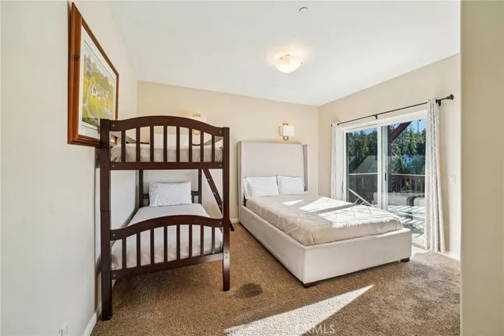 Spacious guest room with slider to the shared deck and peaceful forest outlooks.
