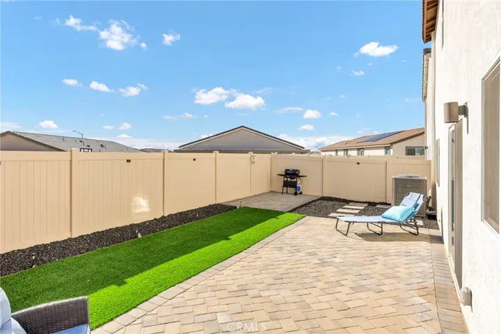 Low-Maintenance Backyard Landscaping with a Patio-Paver Seating Area & Artificial Turf